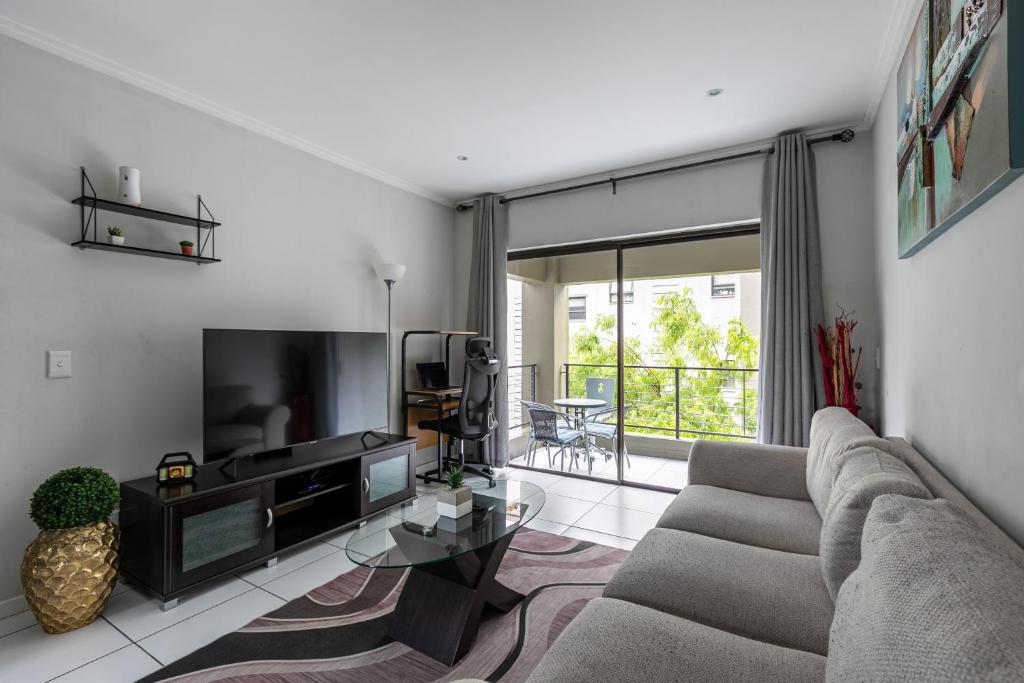 a living room with a couch and a tv at K Luxe Apartment in Sandton