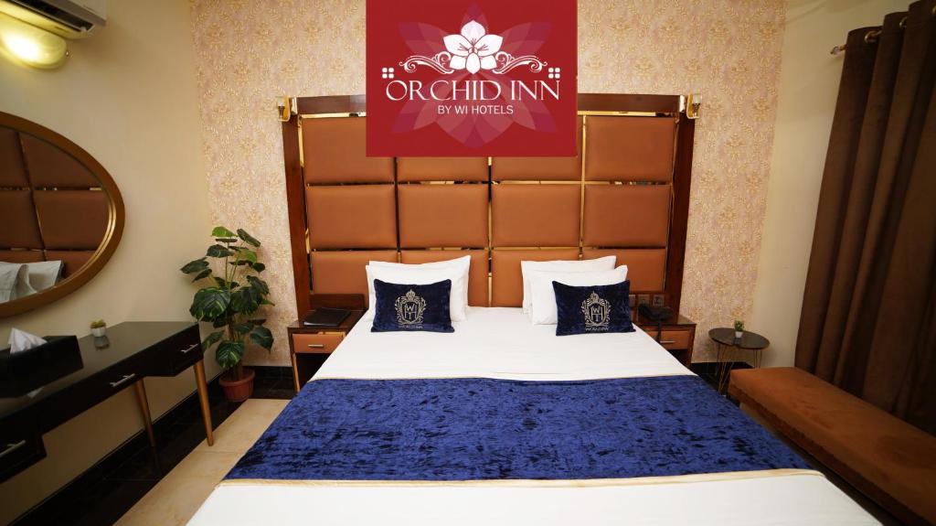 a hotel room with a bed with a blue blanket at Orchid Inn by WI Hotels in Karachi
