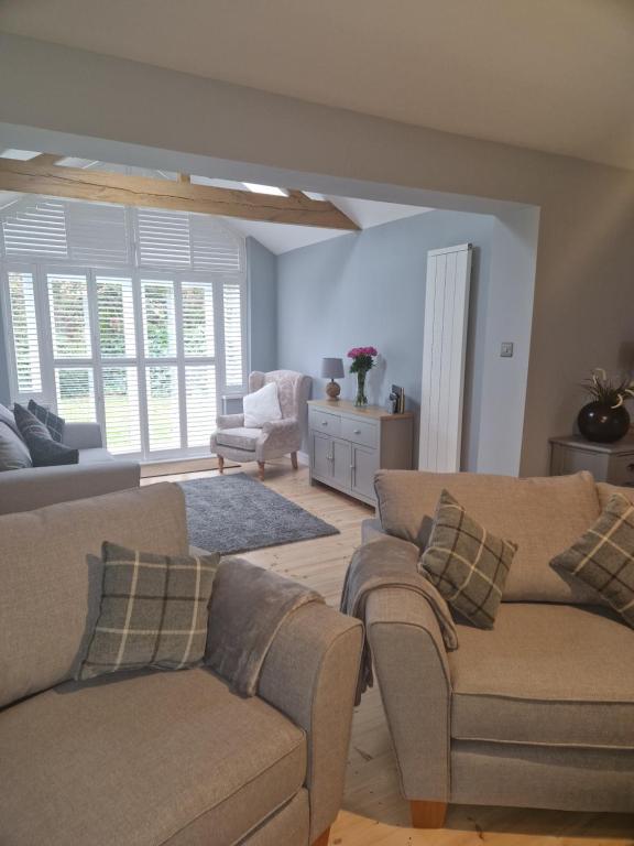 uma sala de estar com dois sofás e uma cadeira em The Haven em Beadnell