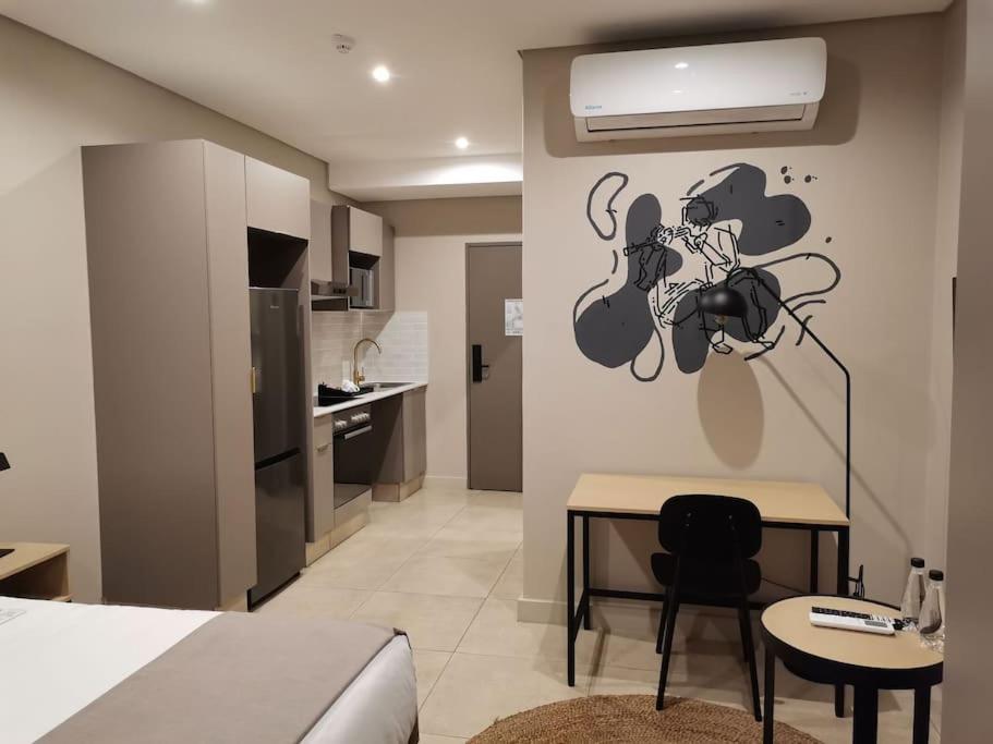 a room with a bed and a table and a kitchen at Studio apartment at Blackbrick 2 in Johannesburg