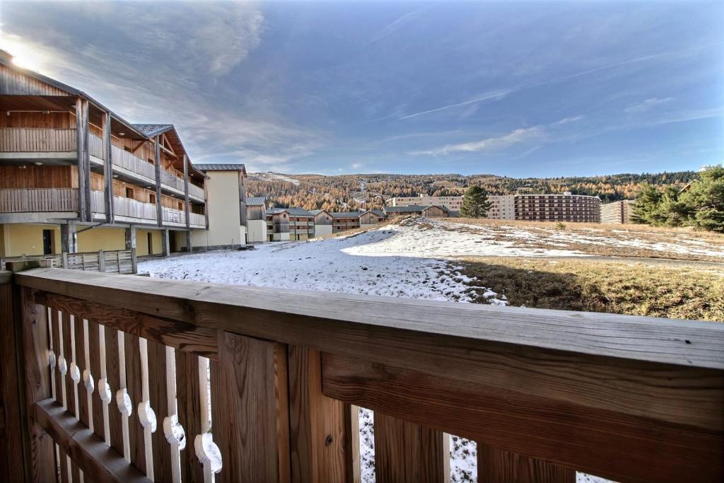 - un balcon en bois avec vue sur la ville dans l'établissement Bright apartment with balcony close to ski slopes, à Saint-Étienne-en-Dévoluy