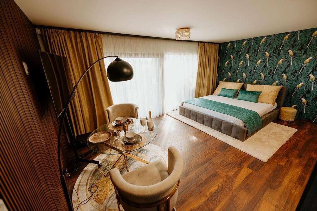 a bedroom with a bed and a table and a tableablish at Lux in the garden Komárno 