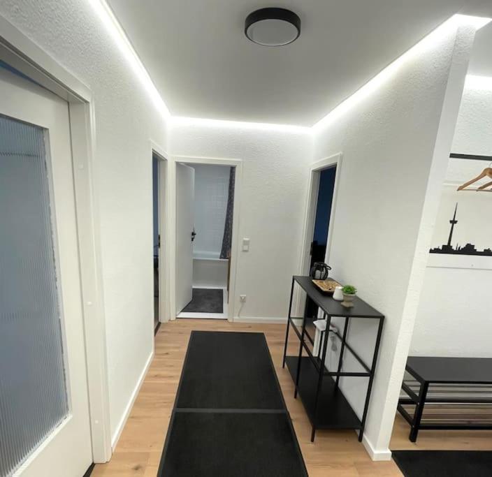 einen Flur mit weißen Wänden und einem schwarzen Teppich in der Unterkunft Panorama-Perle mit 101 m² im Herzen von Köln in Köln