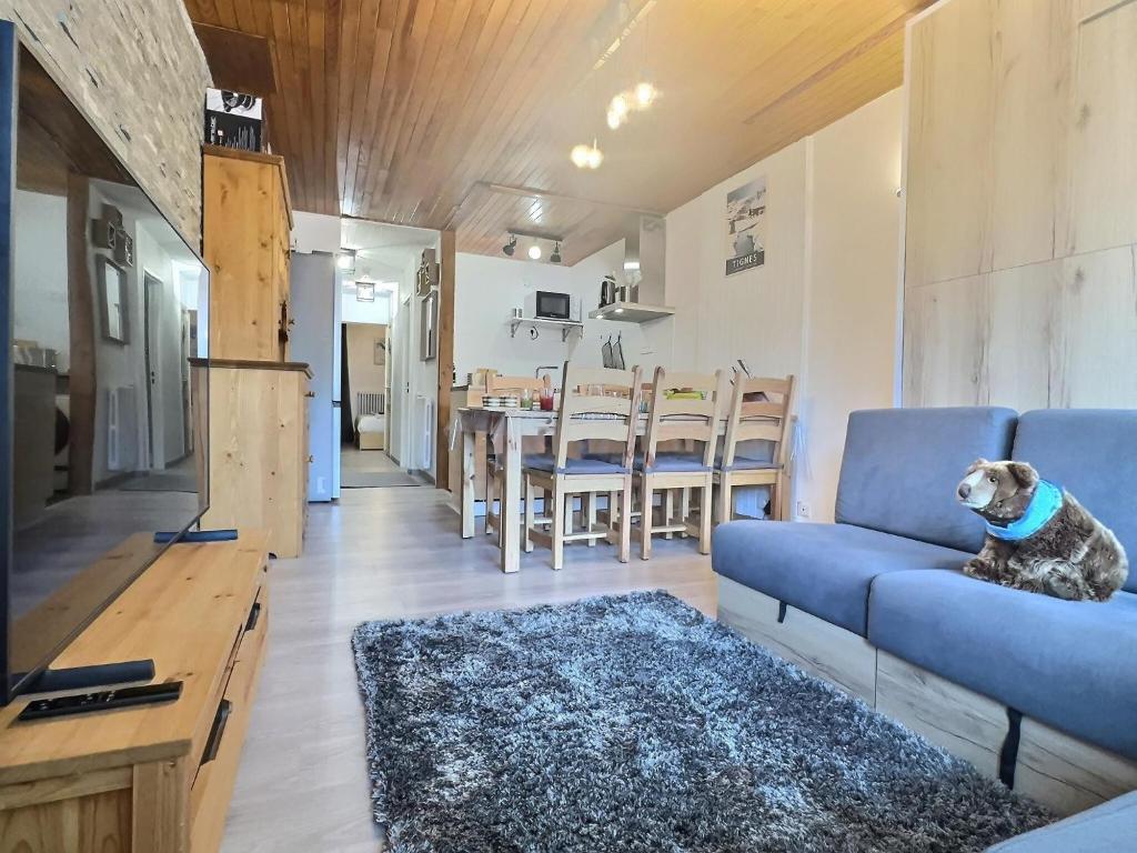 a dog sitting on a couch in a living room at Appartement 6 personnes - 1 chambre - 4 lits - Netflix & wifi haut débit - Parking couvert in Tignes