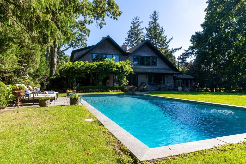 uma casa com piscina em frente a uma casa em Cedar Crest Retreat em Southampton