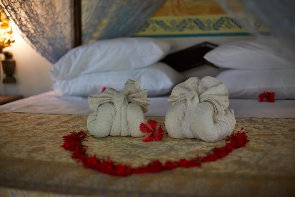 two towels on top of a bed at African House Resort in Malindi