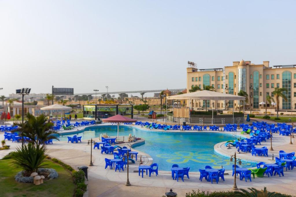 a pool with blue chairs in a resort at Ramage Hotel & Resort in Cairo
