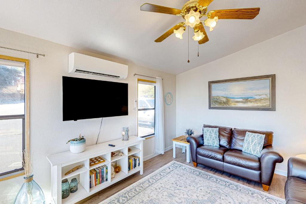 a living room with a flat screen tv and a couch at The Sand Dollar House in Carpenterville
