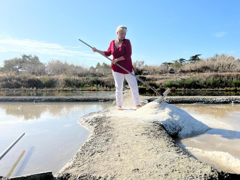 a woman is standing on a rock with a stick at Le Chai Rit in Rivedoux-Plage