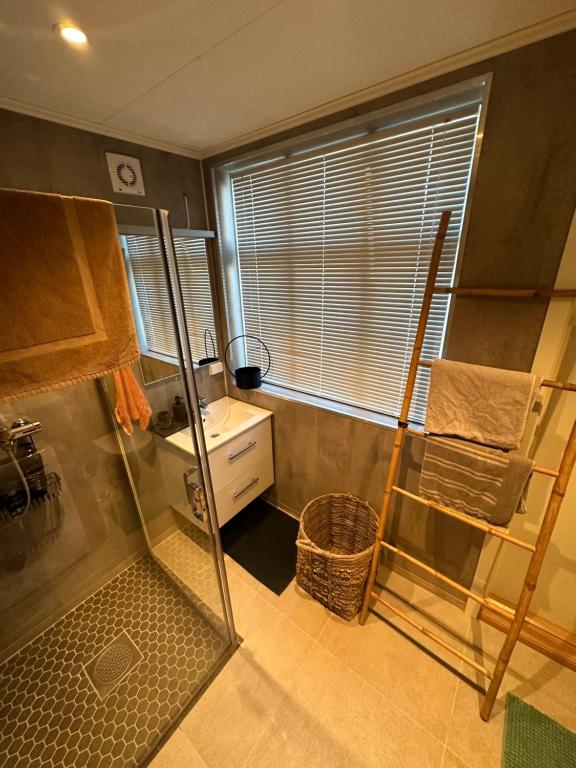 a small bathroom with a shower and a sink at Downtown Historical House with Renovated apartments in Ålesund