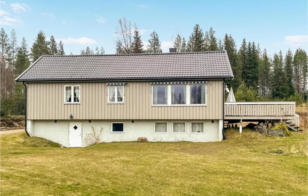 a house with a deck on a yard at Cozy Home In stby With House A Panoramic View in Trysil