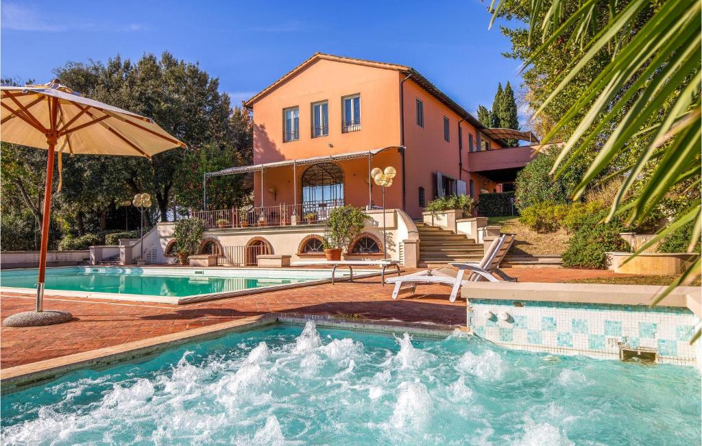 a house with a swimming pool and an umbrella at Pet Friendly Home In Fucecchio With Wi-fi in Fucecchio