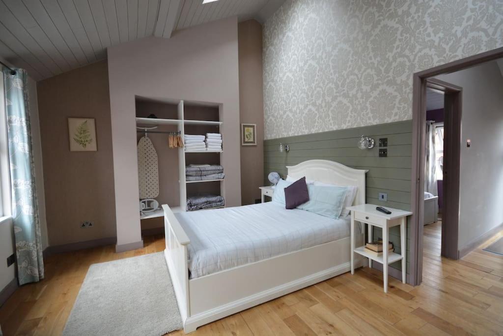 een slaapkamer met een wit bed en een spiegel bij Cheerful 2 bed home with terrace in central Camden in Londen