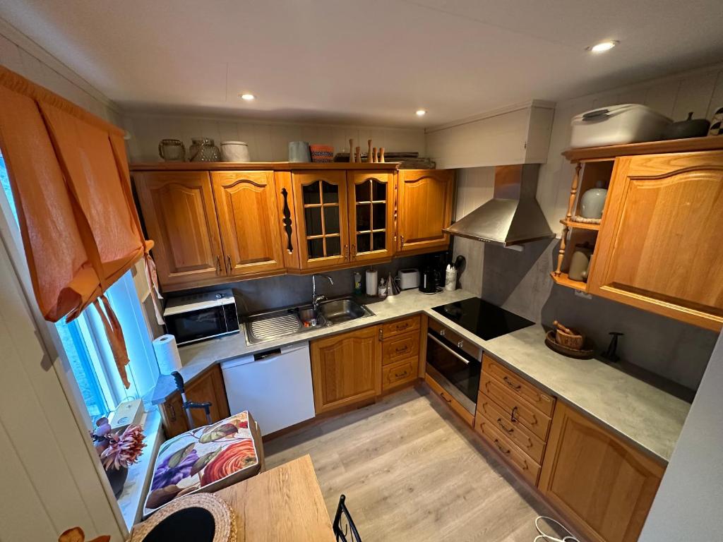 an overhead view of a kitchen with wooden cabinets at Downtown Historical House with Renovated apartments in Ålesund