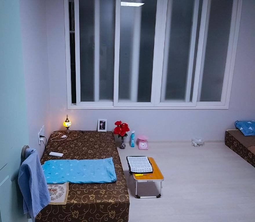 a small bedroom with two beds and a window at 천성리버 아파트 집전체 렌트 in Yangsan