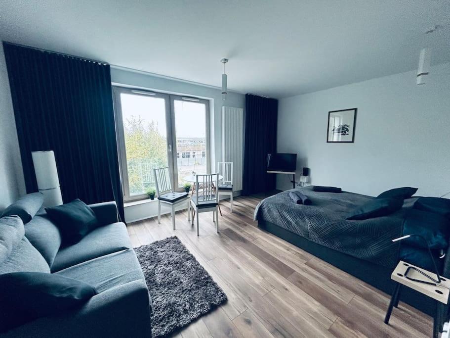 a bedroom with a bed and a couch and a table at Apartament Stary Szczecin in Szczecin
