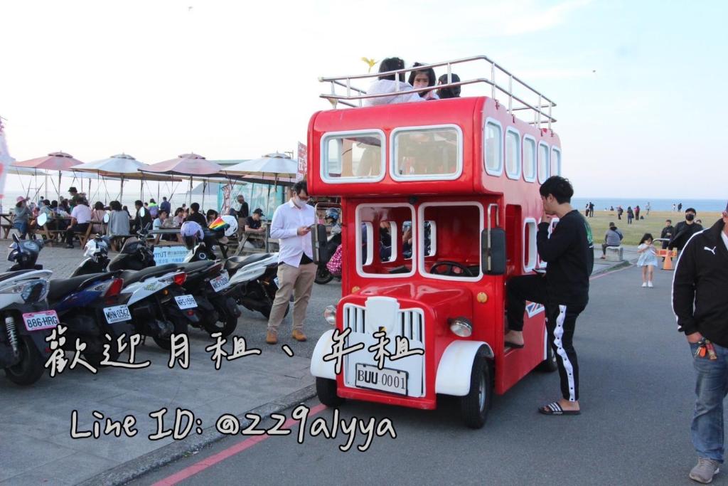 a red double decker bus parked in a parking lot at FJ House ABC in Keelung