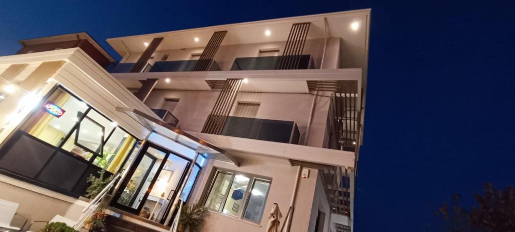 a large white building with a balcony at night at Hotel Ristorante Da Marco in San Mauro a Mare