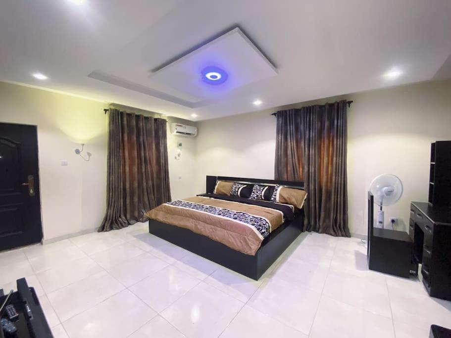 een slaapkamer met een bed en een blauw licht bij Pinnacle Holiday Home Five bedroom House in Lekki