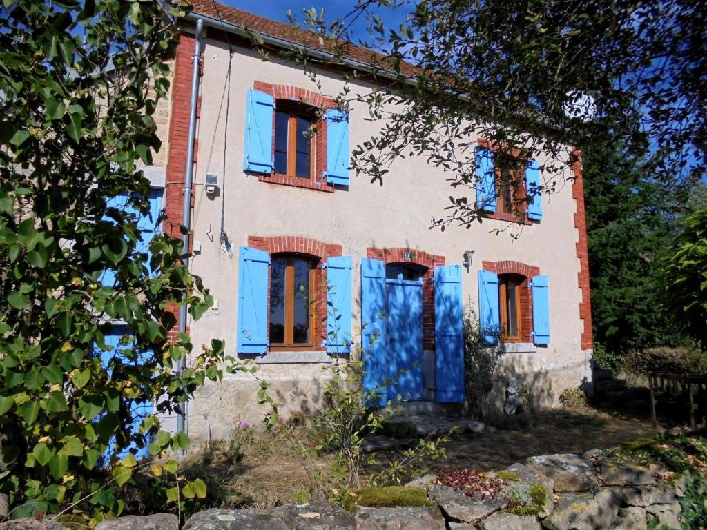 Una casa vieja con persianas azules. en Property in Saint-Julien-La-Genête, en Saint-Julien-la-Genète