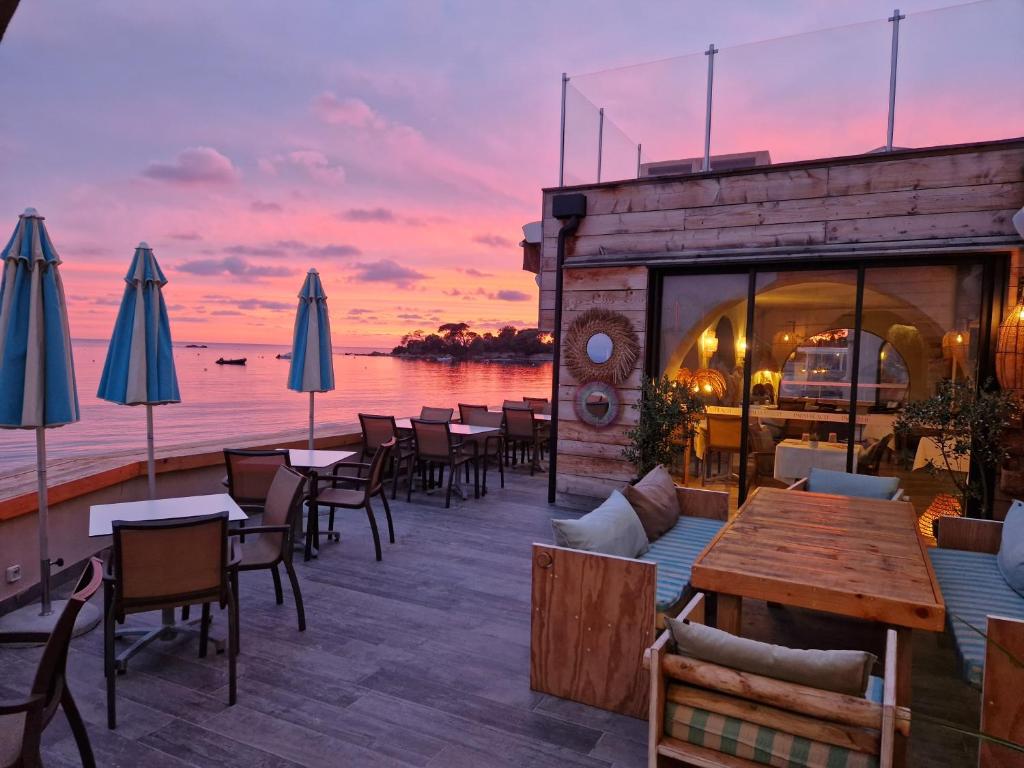 un restaurant avec vue sur l'océan au coucher du soleil dans l'établissement Palm Beach, à Ajaccio