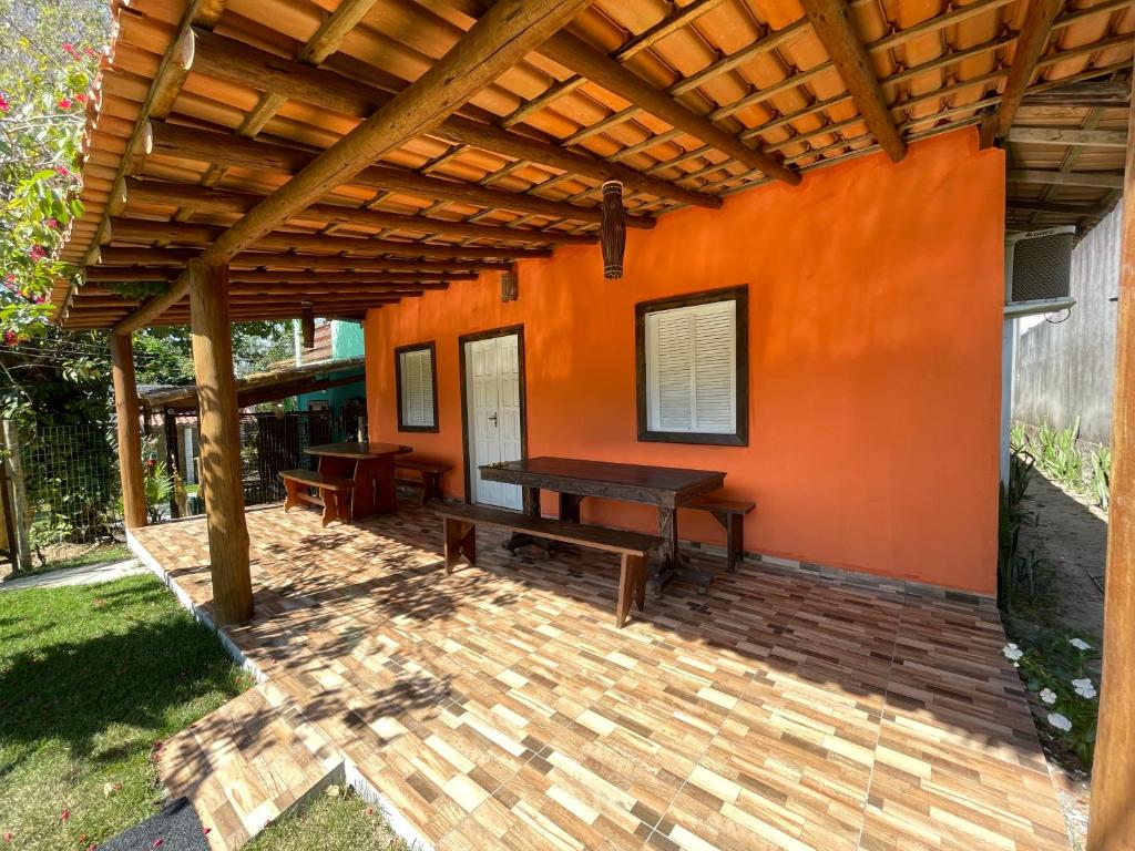 un patio de madera con una mesa y una pérgola de madera en Caraiva Hostel, en Caraíva
