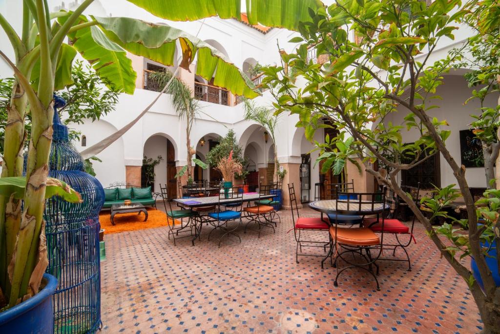 un patio con mesas, sillas y plantas en Riad Le Jardin de Lea, Suites & Spa en Marrakech