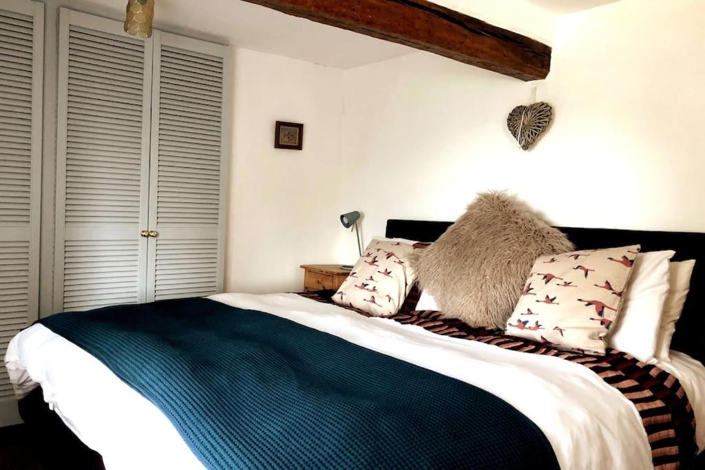 een slaapkamer met een groot bed met kussens erop bij Cosy 3 Bed Cottage near 3 Peaks - Log Burner & Aga in High Bentham