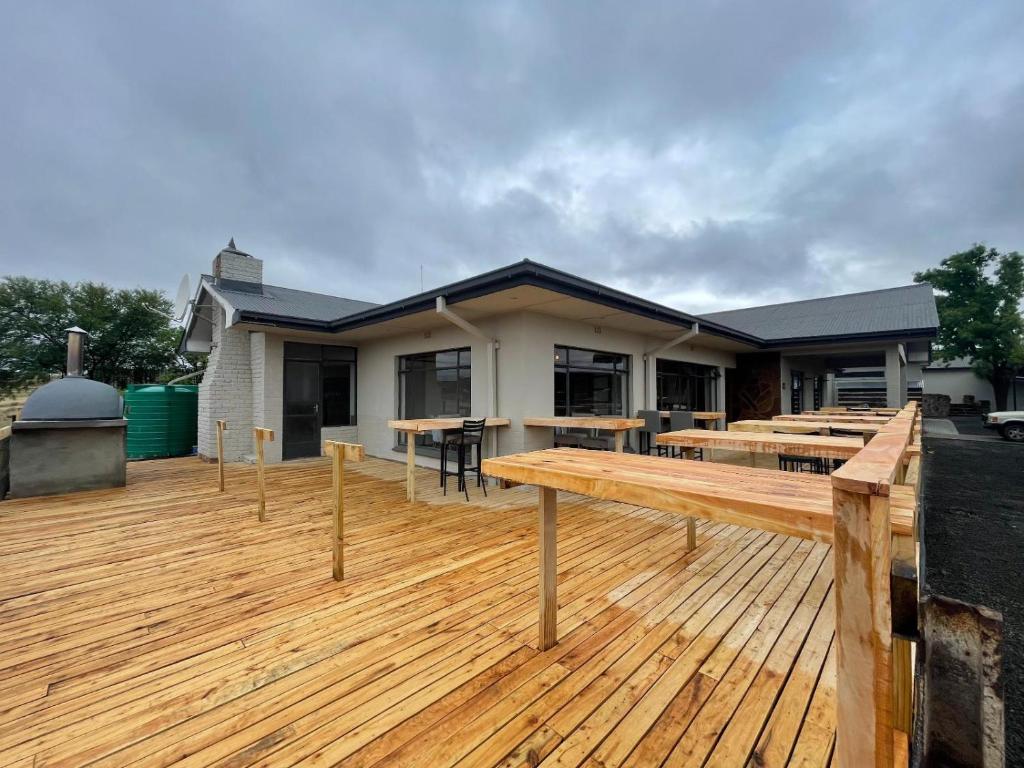a large deck with tables and a house at Heydays B&B in Noupoort