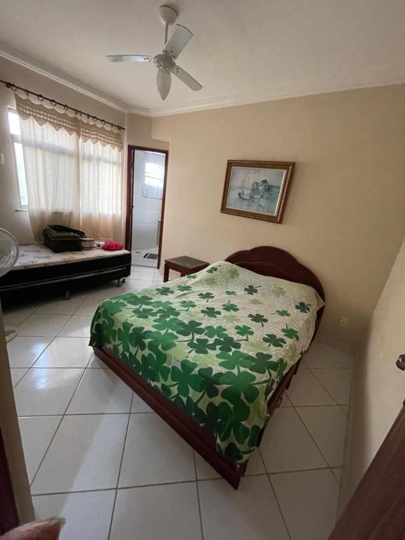 sypialnia z łóżkiem z zieloną kołdrą w obiekcie Condomínio Verdes Mares w mieście Arraial do Cabo