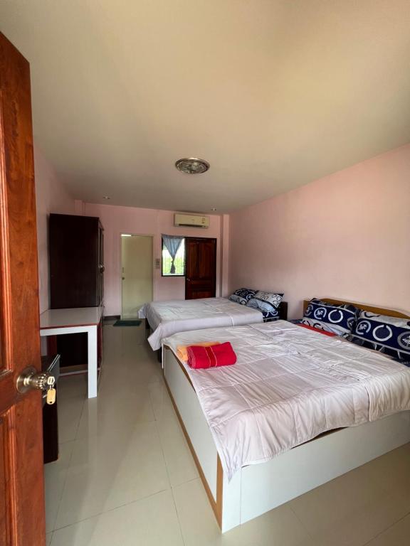 a bedroom with two beds and a flat screen tv at ที่พักสกลนคร กิตติวัฒน์อพาร์ทเม้นท์&รีสอร์ท in Sakon Nakhon