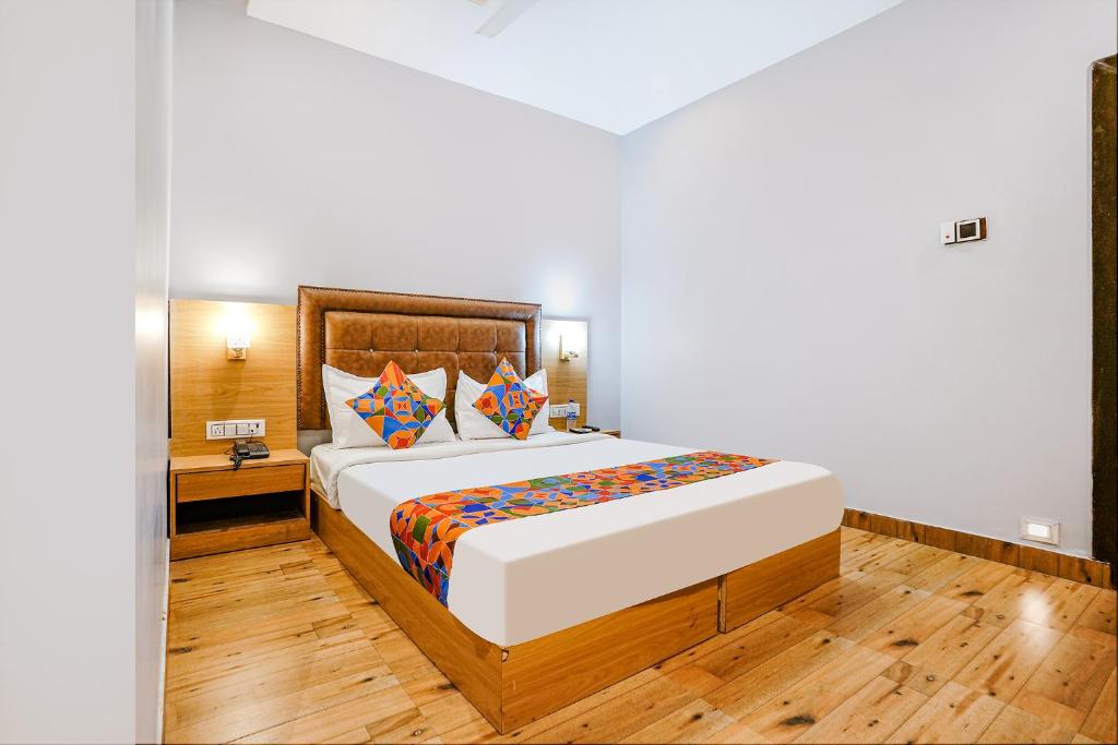 a bedroom with a large bed and a wooden floor at FabHotel Zara Grand in Mumbai