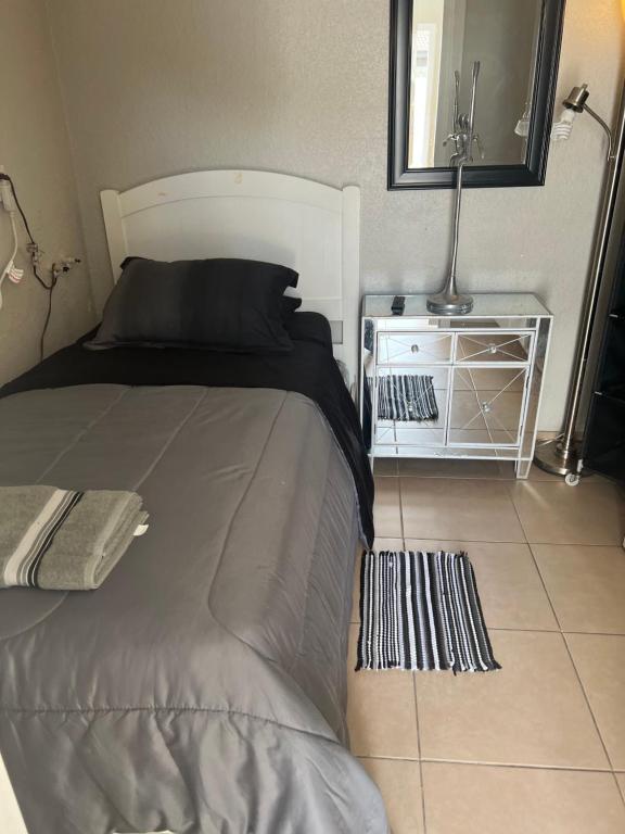 een slaapkamer met een bed, een spiegel en een tafel bij bedroom private in Miami