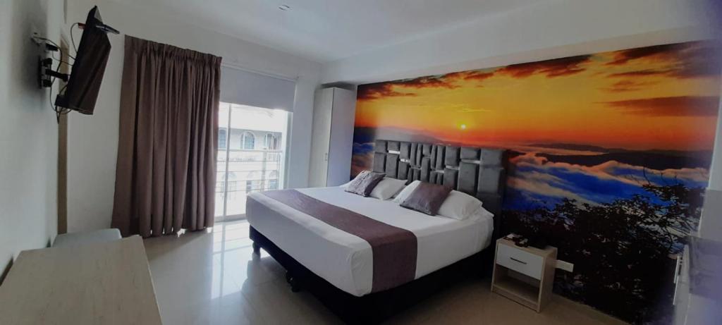 um quarto com uma cama com um quadro na parede em Hotel Granada Loft em Cali