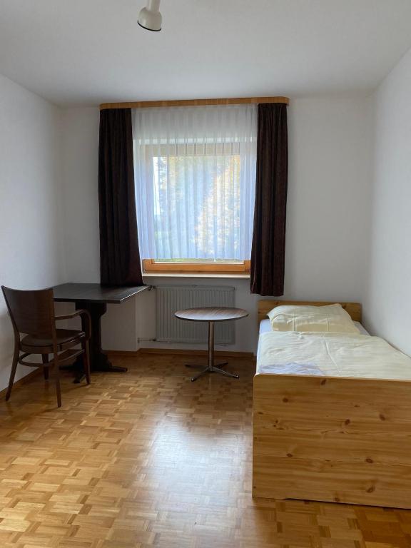 Un dormitorio con una cama, un escritorio y una mesa. en Ruhige 4 Zimmer EG-Wohnung Z1, en Königsbronn