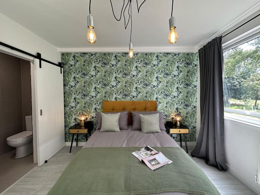 a bedroom with a bed with a green wall at Chic 5-BR, all ensuites with TVs in London