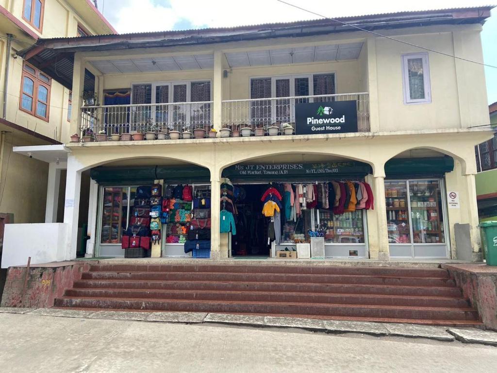 un magasin devant un bâtiment avec un balcon dans l'établissement Pinewood guesthouse, à Tawang