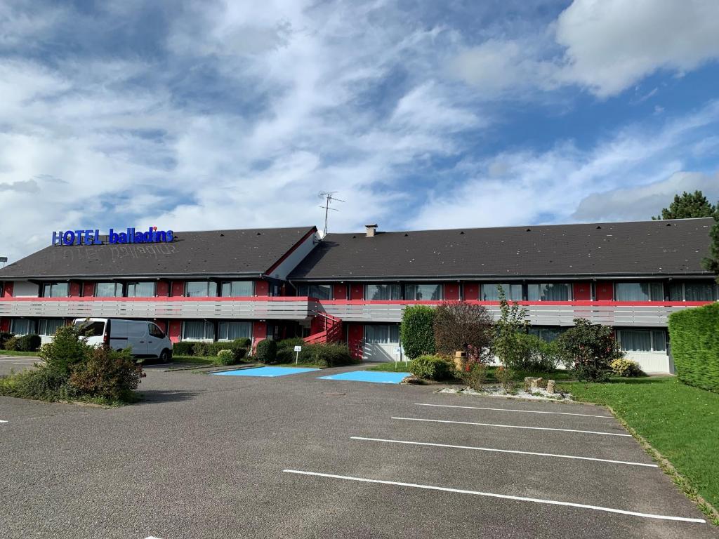 un hotel con un estacionamiento delante de él en Initial by balladins Dieppe en Saint-Aubin-sur-Scie