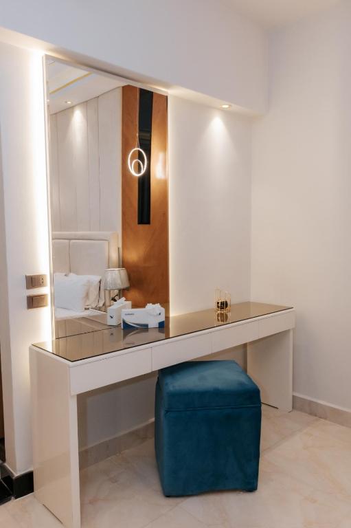 a dressing table with a mirror and a blue stool at Ramage Hotel & Resort in Cairo