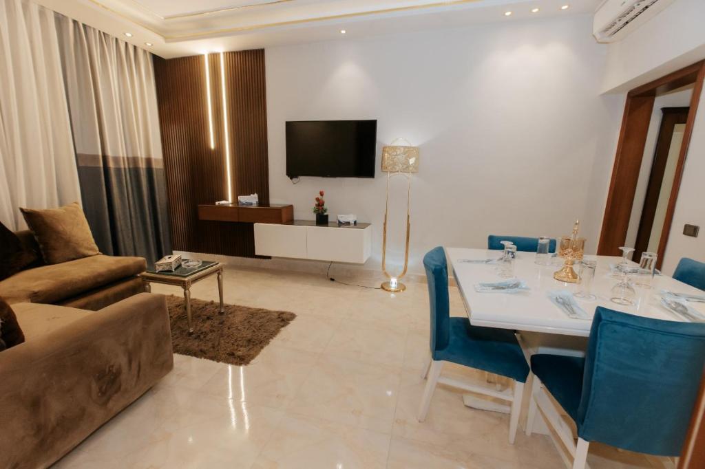 a living room with a couch and a table with blue chairs at Ramage Hotel & Resort in Cairo