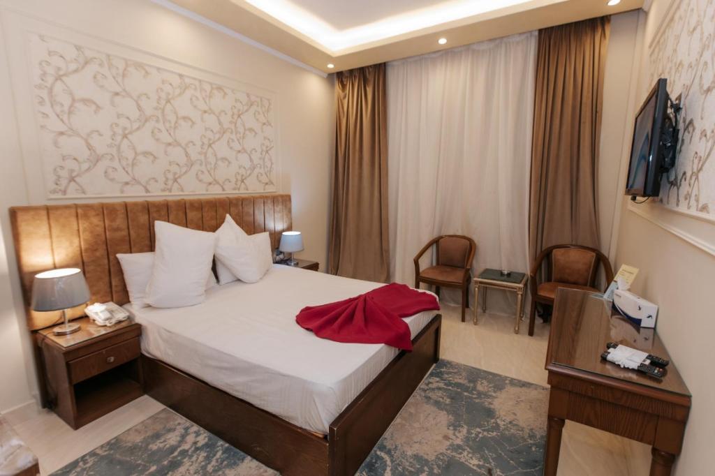 a hotel room with a bed and a desk and a television at Ramage Hotel & Resort in Cairo