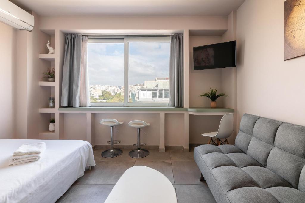 テッサロニキにあるAristotle Spot, City View Apartment by BiNoBi!のソファと窓のあるリビングルーム
