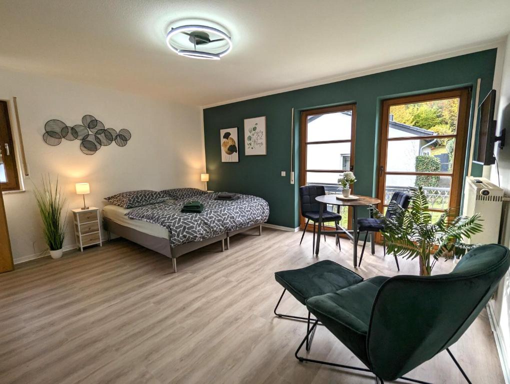 a bedroom with a bed and a table and chairs at K-TOWN GREEN Studio Apartment in Kaiserslautern