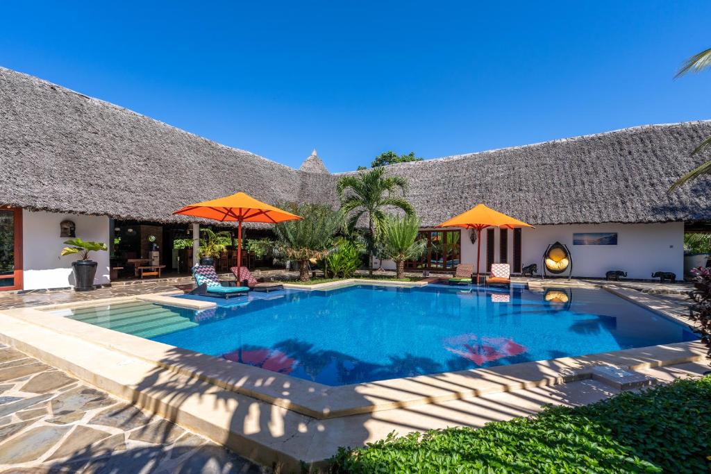 a swimming pool in front of a house at Villa Raymond, Diani, Kenya in Diani Beach