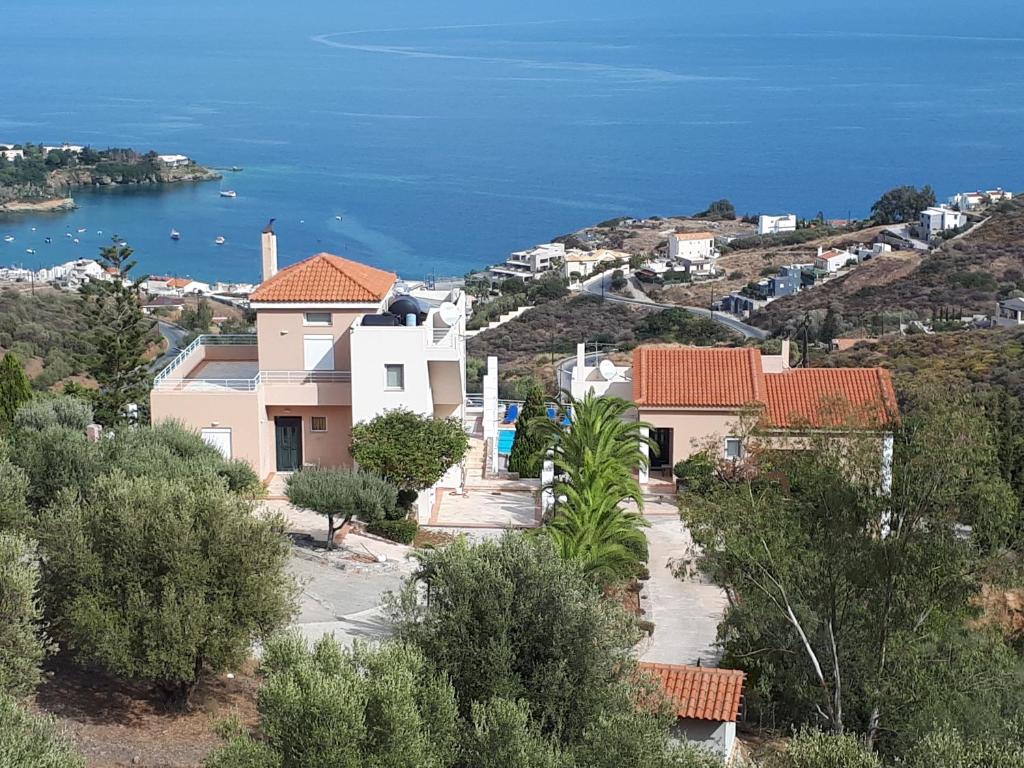 een groep huizen op een heuvel naast de oceaan bij Agnanti Villas in Agia Pelagia