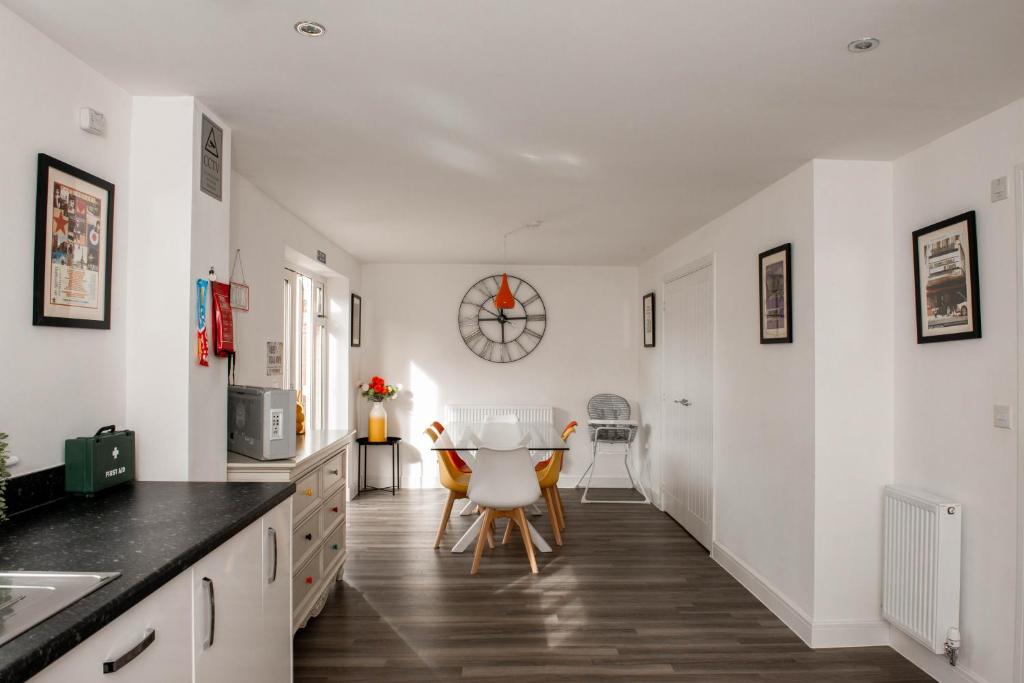 uma cozinha com paredes brancas e uma mesa e cadeiras em Spacious & Stylish 4-Bed House with Hot Tub in Prime Location em Southampton