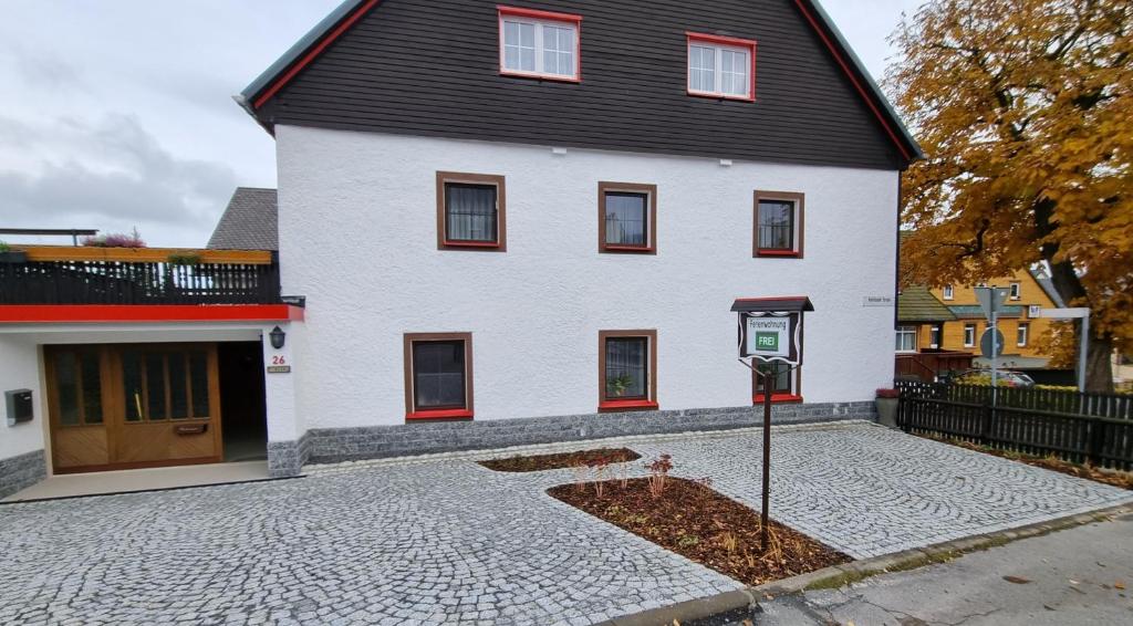 a white house with a parking meter in front of it at Haus Blach in Kurort Oberwiesenthal