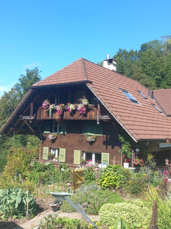 una casa con un balcón con flores. en Bright, sunny holiday apartment on the farm 
