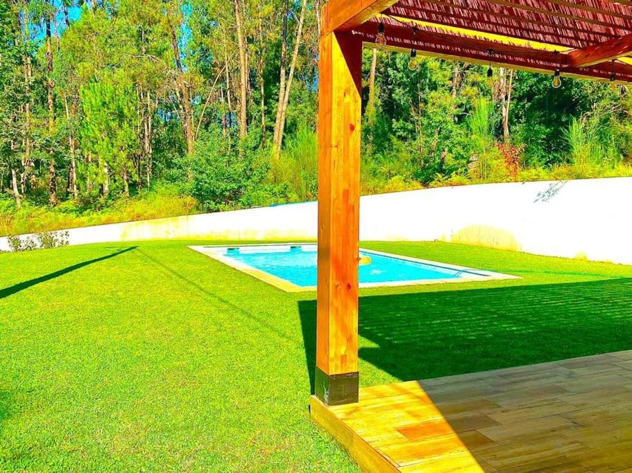 ein Schwimmbad in der Mitte eines Grasfeldes in der Unterkunft Casa do Bosque in Vila Nova de Cerveira