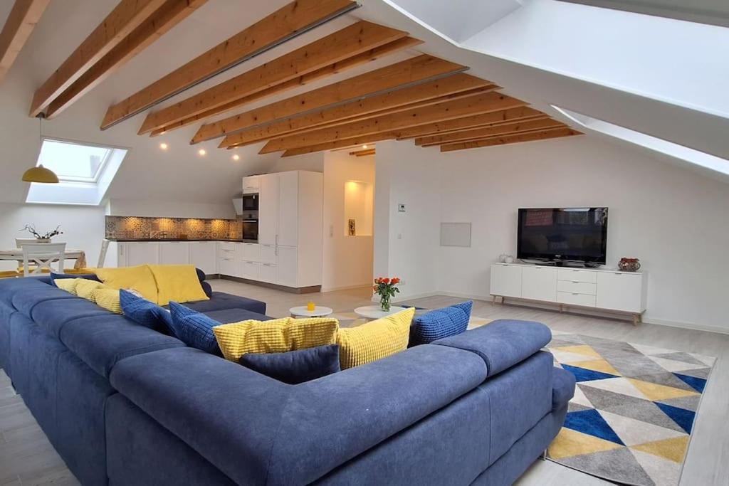 uma sala de estar com um sofá azul e uma televisão em Gemütliche Wohnung in Bissingen em Bietigheim-Bissingen